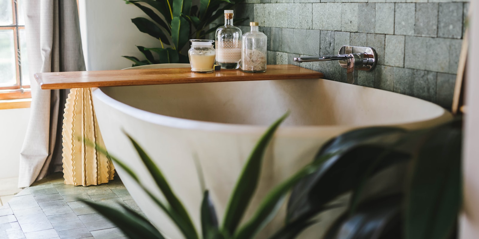 Plantes vertes posées dans une salle de bain lumineuse et carrelée